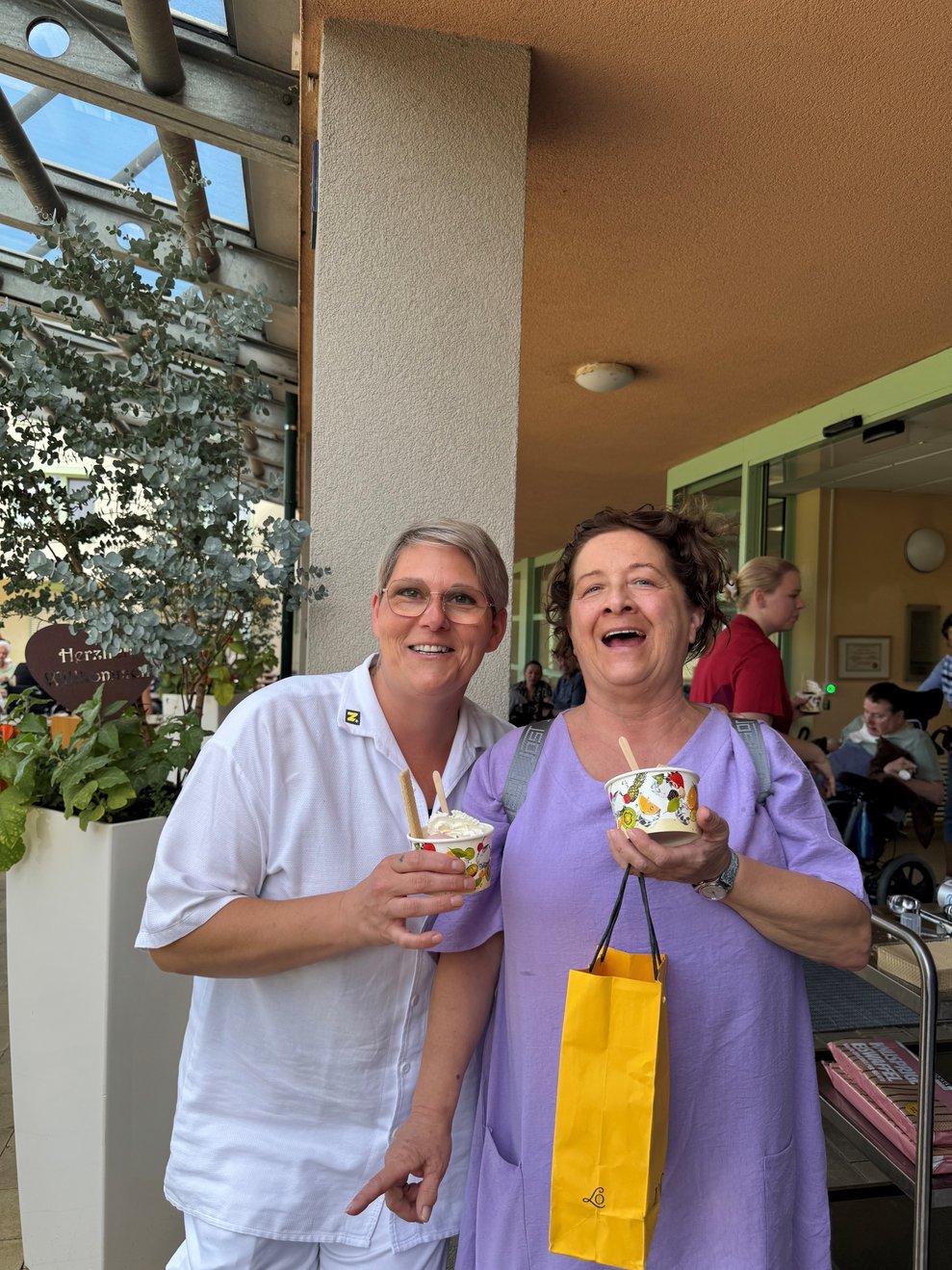 Zwei Damen lächeln mit dem Eis in der Hand.